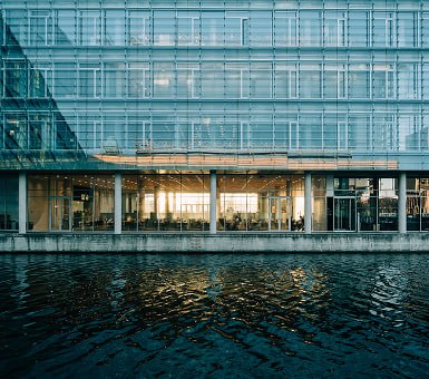 Waterfront glass office building at dusk