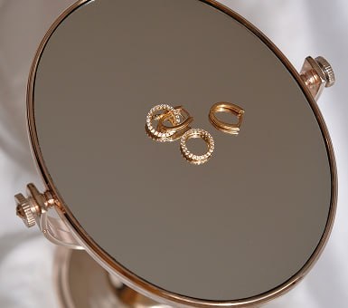 Fine jewelry displayed on a mirrored tray