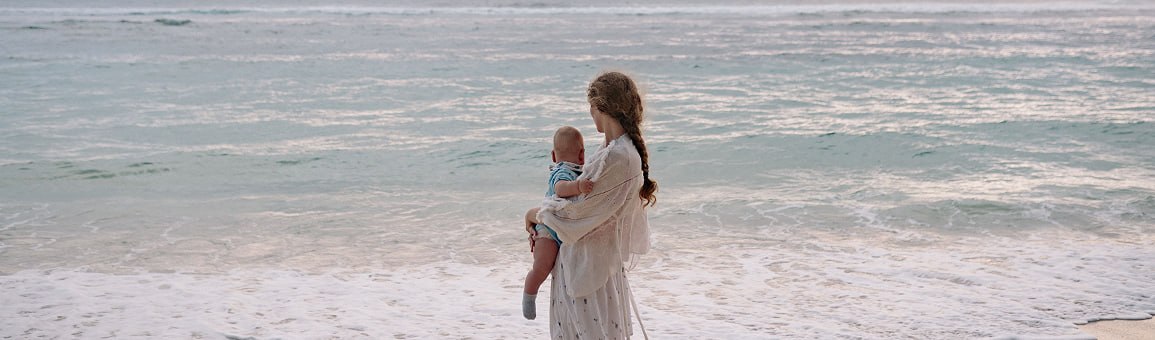 Mother holding her child at the shoreline